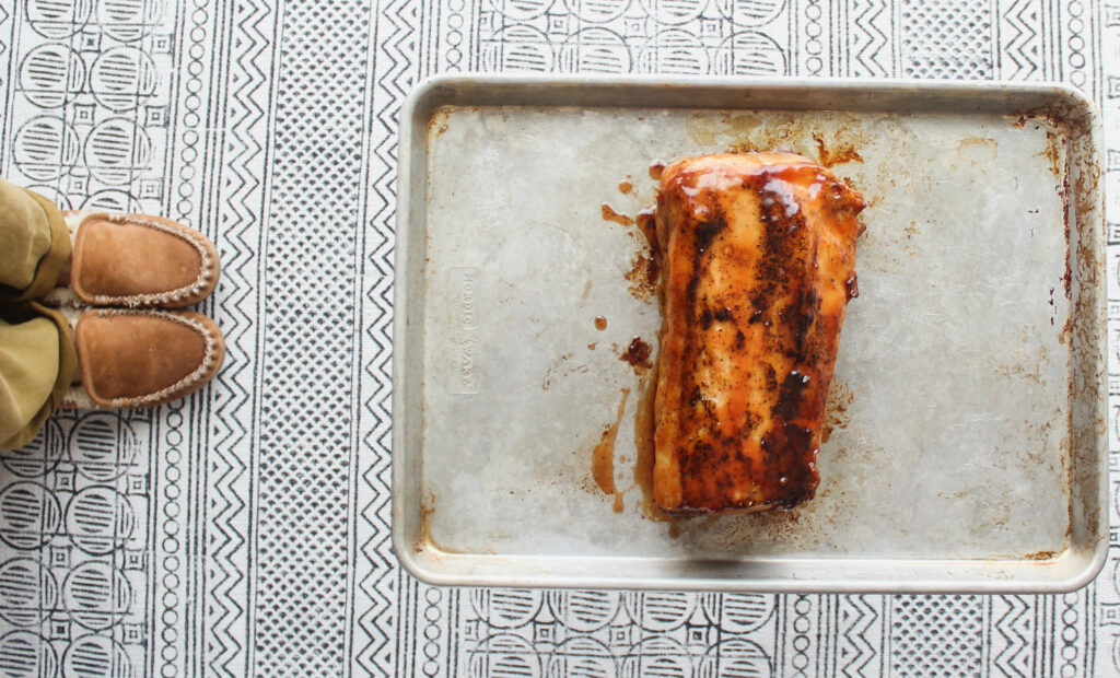 The pork is basted with sweet and sour sauce and placed in the oven to roast.