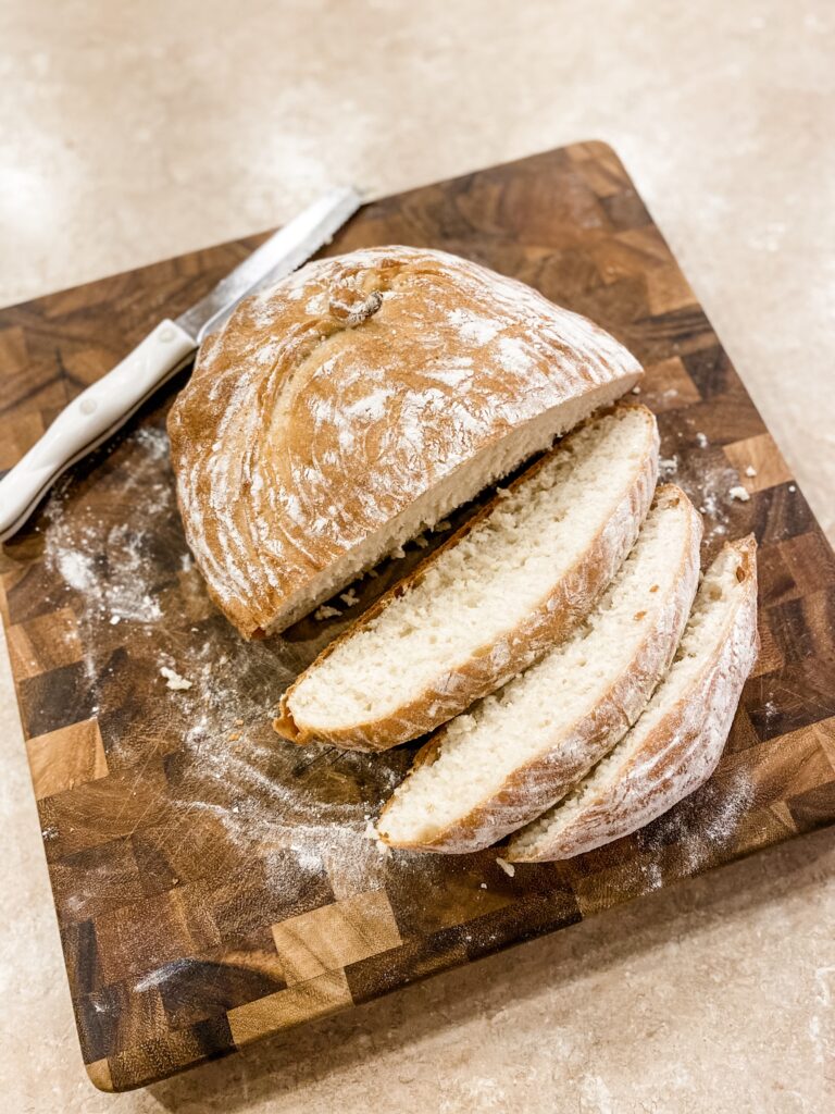 Homemade Dutch Oven Loaf sliced on cutting board.