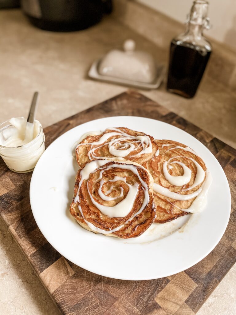 Three cinnamon swirl pancakes with frosting.