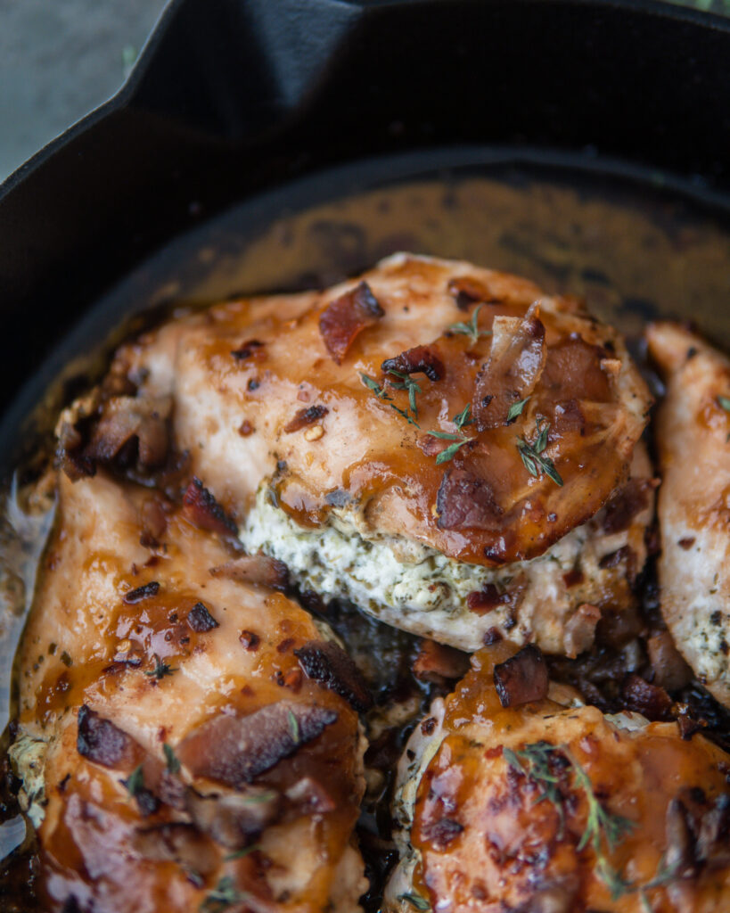 Close up of Apricot Chicken Stuffed w. Herby Goat Cheese in cast iron skillet.