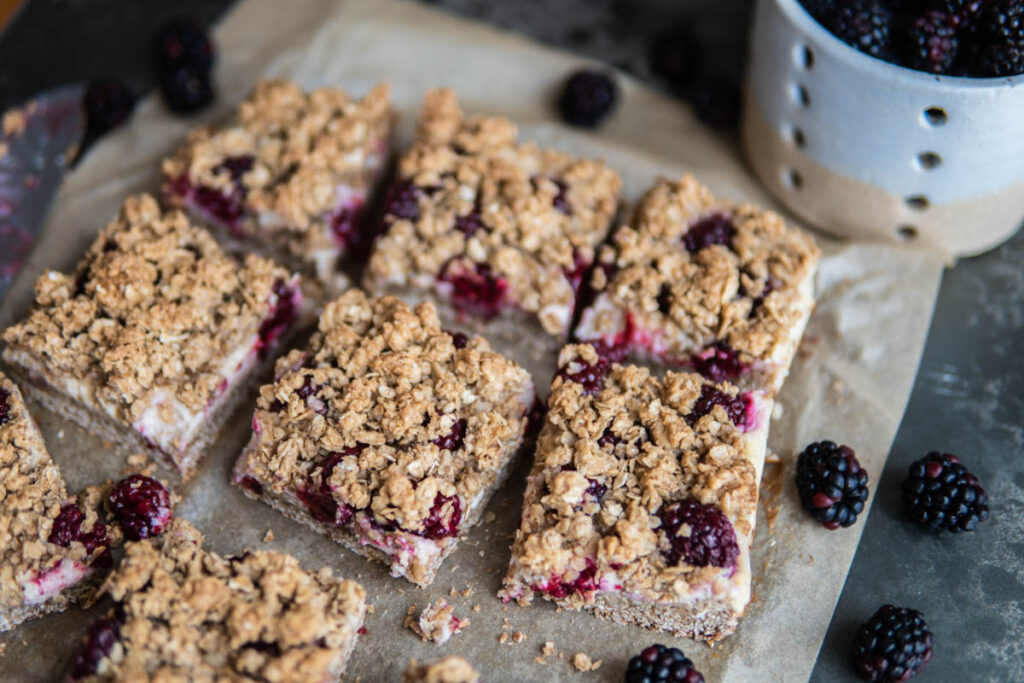 Sliced Blackberry Cheesecake Oat Bars on table surface.