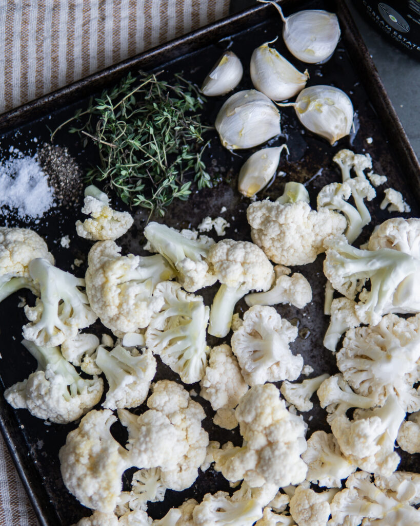 Ingredients for Garlic Parmesan Roasted Cauliflower on a baking sheet before cooking.