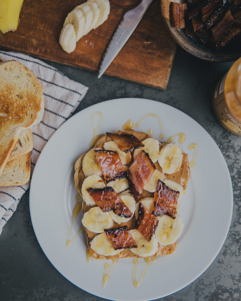 Full plate shot with pile of toast to the left and sliced of banana above the plate. 