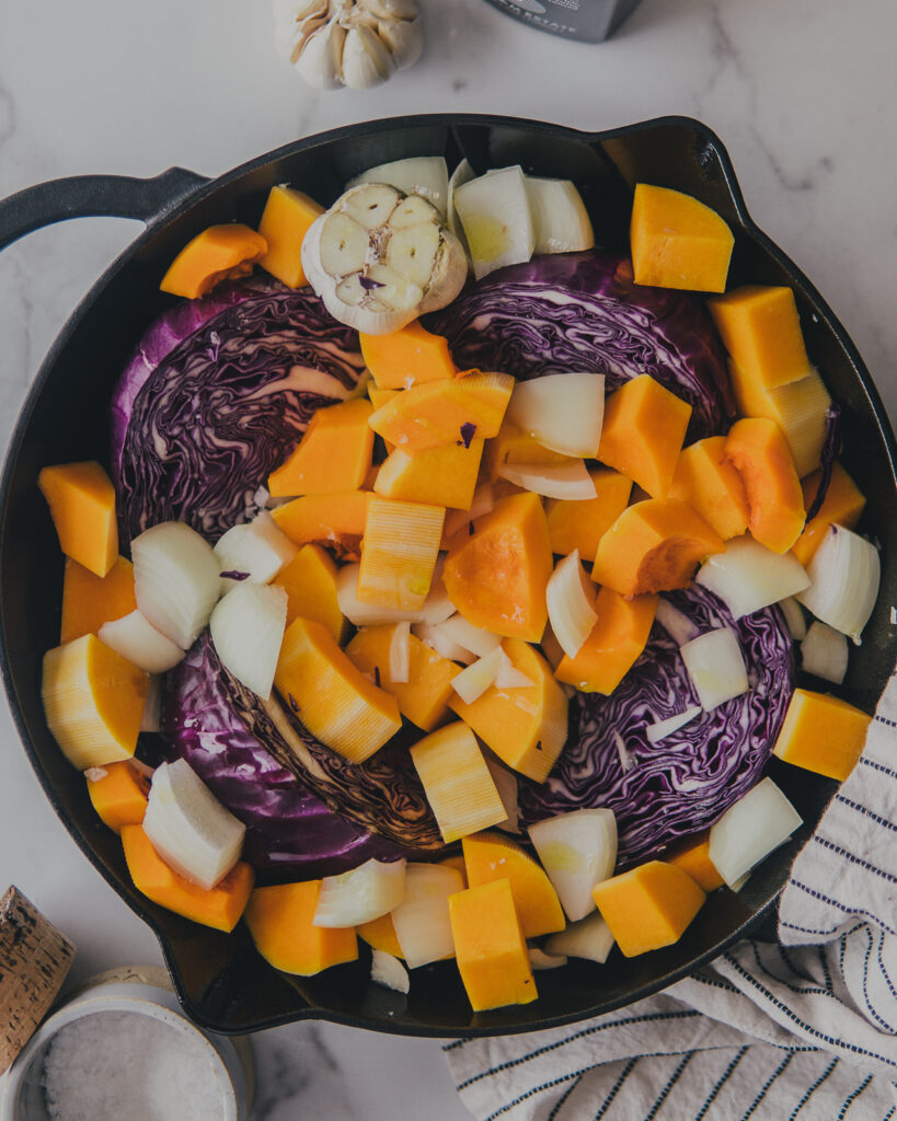 Cabbage, butternut squash and onions in a cast iron pan.