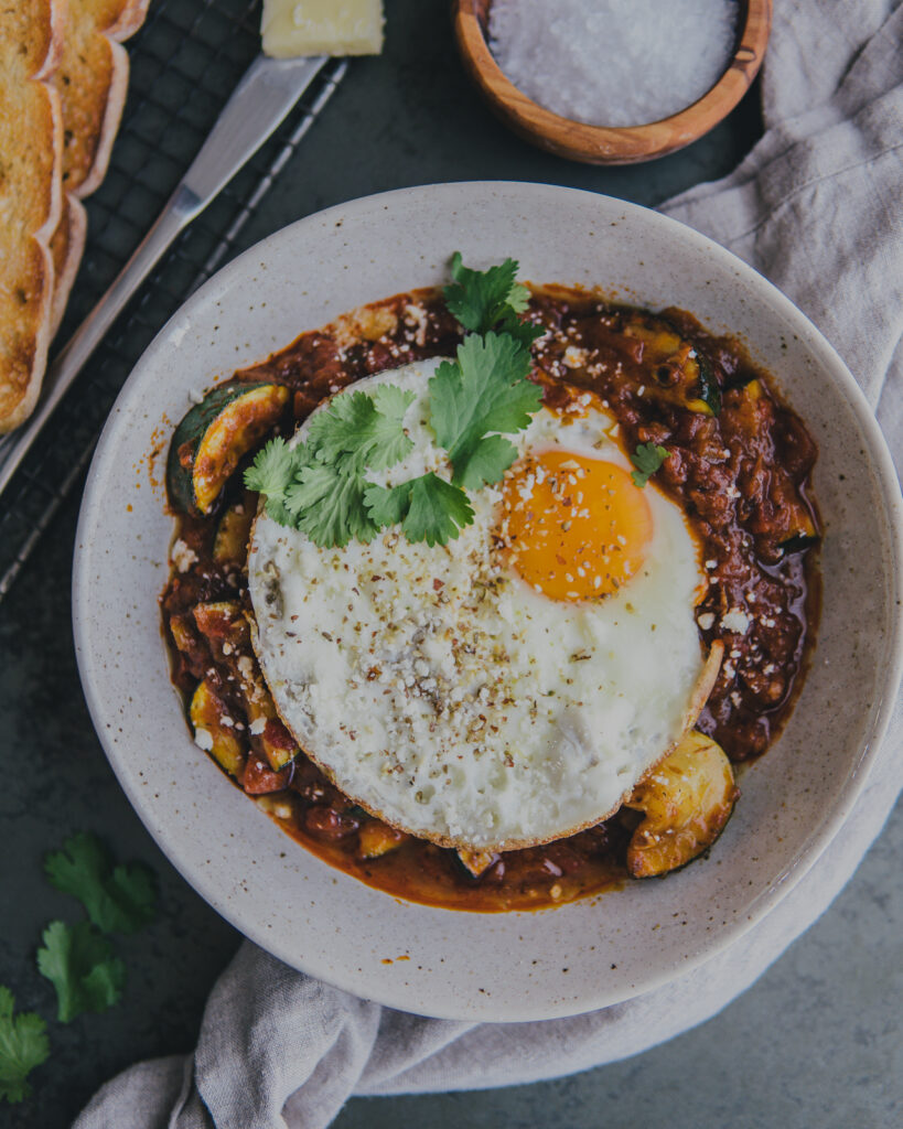 Full bowl of Sunday Brunch Shakshuka with a fried egg on top. 