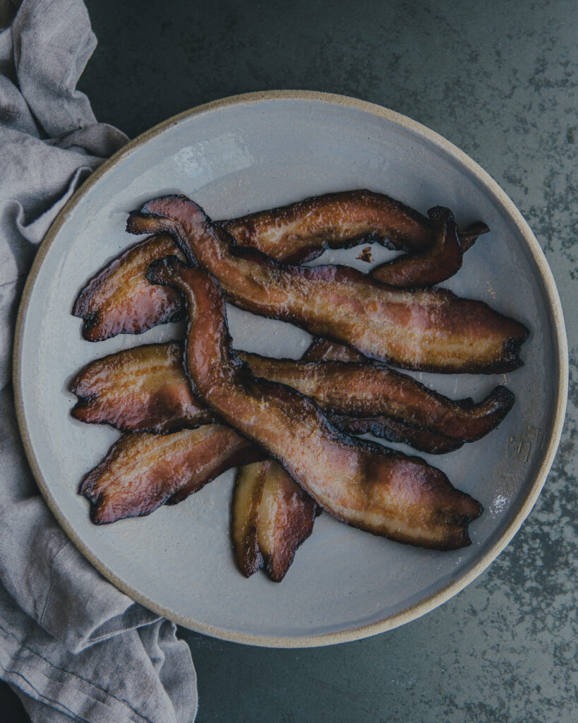 Plate of crispy sheet pan bacon, baked to perfection.