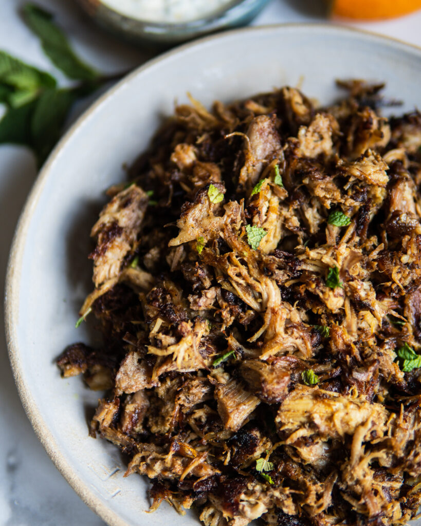 Crispy and plated Moroccan Spiced Pork Butt with Citrus Mint Yogurt.