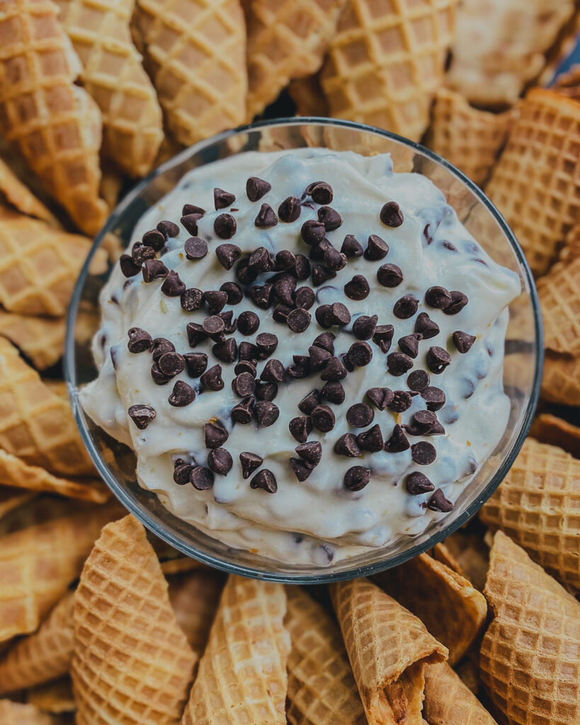 Easy Cannoli Dip in the center with broken waffle cones all around. 