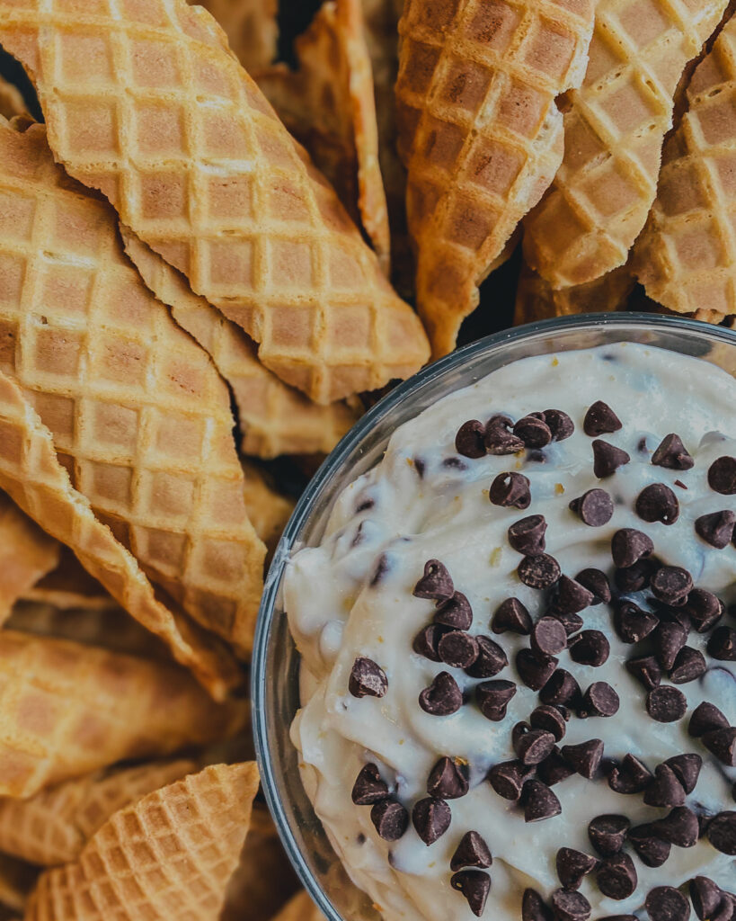 Side angle of Easy Cannoli Dip in the center with broken waffle cones all around. 