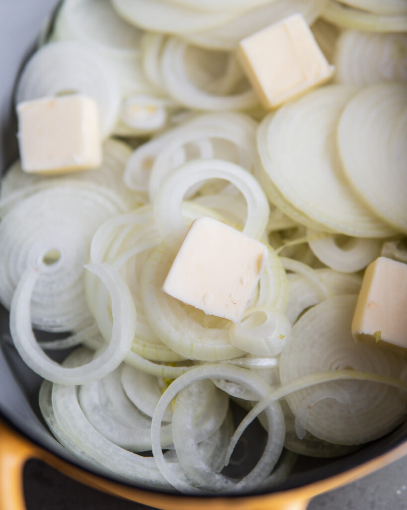 Sliced onions with pats of butter.