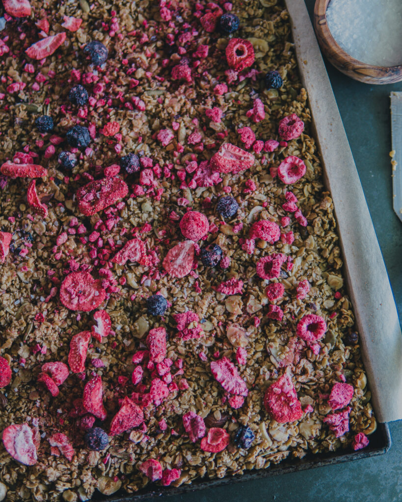 Full sheet pan view of berry topped granola.