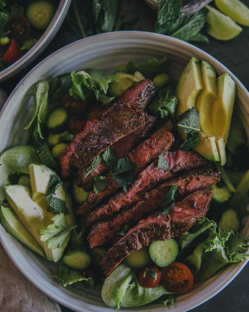 Smoky Flat Iron Steak Salad in a large glass bowl. 