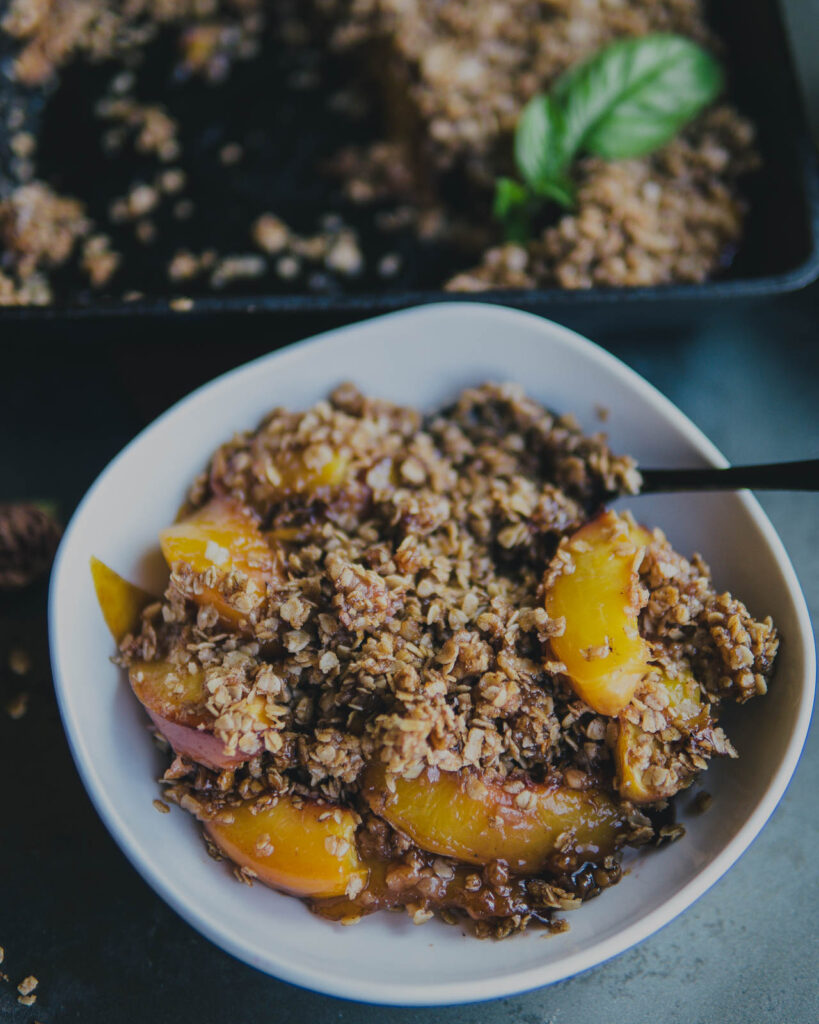 Traeger Nectarine Crisp in a bowl with a spoon ideally for Labor Day Weekend Menu BBQs.