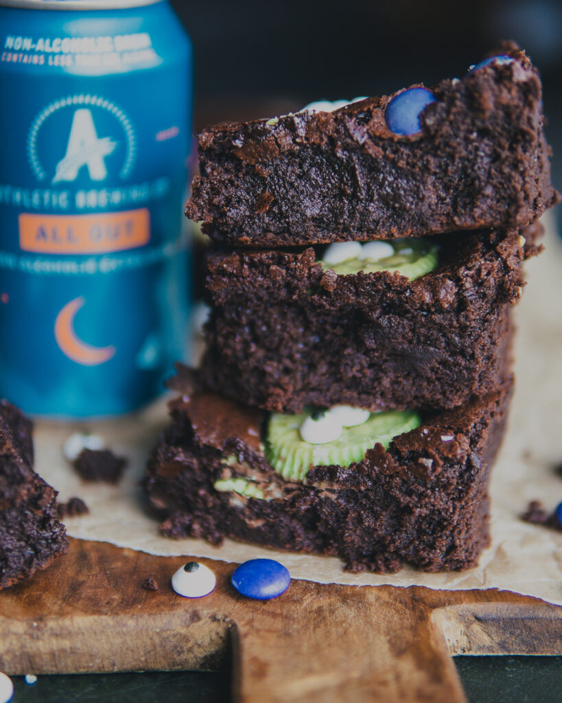 Stack of brownies next to a can of Athletic Brew beer. 