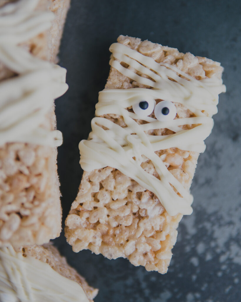 A rice cereal mummy marshmallow holiday treat with candy eyes and white chocolate mummy wraps, 