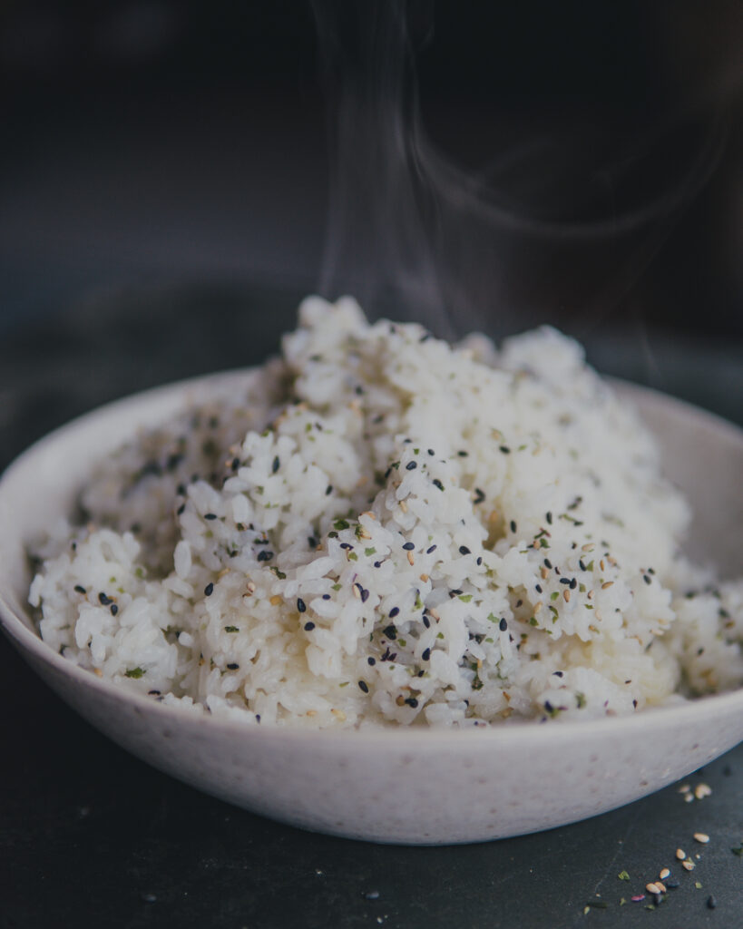 White rice in a bowl topped with sesame seeds.